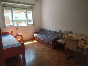 a room with a couch and a bed and a table at Apartamento 3 minutos da orla in Capão da Canoa