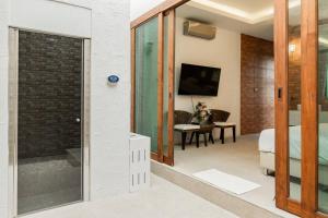 a bedroom with a glass door leading to a bathroom at Unique Lanna Style Spa Pool Villa in Chiang Mai