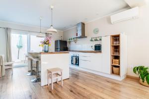an open kitchen with white cabinets and a counter at Windmill Escape - Onda Townhouse in Odeceixe