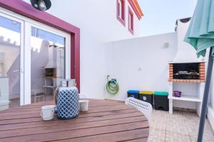 a room with a wooden deck with a table and chairs at Windmill Escape - Onda Townhouse in Odeceixe