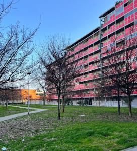 ボローニャにあるMaison Paradiso - Santa Viola Apartmentの目の前に木々が植えられた大きな赤い建物
