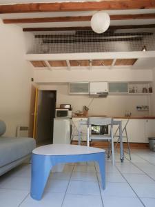 a living room with a blue table and a kitchen at Cabanon Calanque Marseille in Le Rove