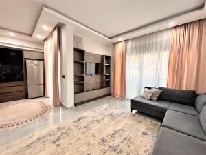 een woonkamer met een bank en een groot raam bij İris Apartment Belek A1 in Belek