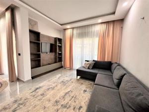 ベレキにあるİris Apartment Belek A1のリビングルーム(黒いソファ、テレビ付)