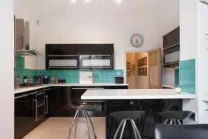 a kitchen with black cabinets and a white counter top at Bright & spacious modern 2 bedroom apartment in London