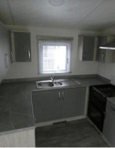 uma cozinha com um lavatório e uma janela em Langford Lodge em Great Billing