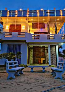 two benches in front of a house at night at SHARAH Beach Resort in Addalachenai