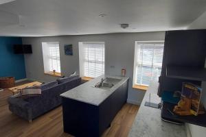 a kitchen and living room with a couch and a table at The Old Coach House in Aberaeron