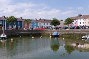 a body of water with boats and houses and buildings at The Old Coach House in Aberaeron