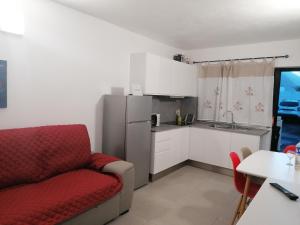 una cucina con divano rosso e frigorifero di Vivienda El Remo-Vv-3 a Los Llanos de Aridane