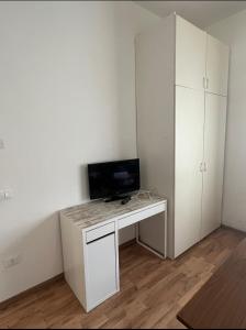 Habitación con escritorio blanco y TV. en B&B Treviso, en Treviso
