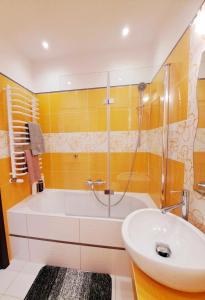 a bathroom with a tub and a sink at Apartament Mazurska Natura in Szczytno