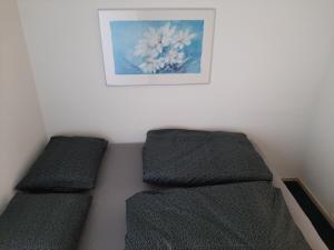 two beds in a room with a picture on the wall at Huisje Earrebarre in Tzummarum