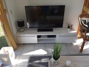 a large flat screen tv sitting on a white entertainment center at Huisje Earrebarre in Tzummarum