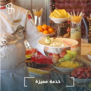 a chef holding a tray of fruits and vegetables at Sheek Hotel in Erbil