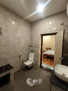 Un baño con lavabo, inodoro y una cama. en Sea Breeze at ECR - Beach Front Villa with Private Pool, Jacuzzi and Dive-in Theater, en Tirupporūr