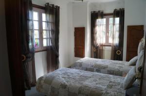 a bedroom with two beds and two windows at Le Relais De Dalibray in Seraincourt