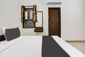 1 dormitorio con 1 cama y puerta de madera en Collection O Hjp en Narela