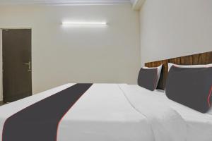 1 dormitorio con 1 cama grande y 2 sillas en Collection O Hjp en Narela