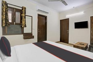 a bedroom with a bed and a tv on the wall at Collection O Hjp in Narela