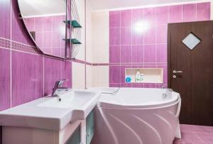 a pink bathroom with a tub and a sink and a mirror at Tampa Holiday Vila in Braşov