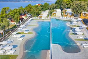 an aerial view of a resort swimming pool with lounge chairs at SEA HOUSE pool & jacuzzi - PRIVILEGE POINT camping & villas in Selce