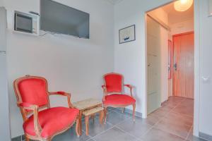 due sedie rosse e una tv a muro di « Château Saint Louis 3 » Vue Mer, Terrasse a Mentone