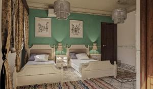 een slaapkamer met 2 bedden en een groene muur bij Eileen Hotel Cairo in Caïro