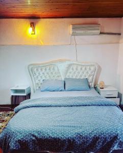 a bedroom with a bed with a blue comforter at Elite Rooms in Fethiye