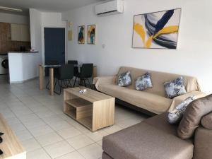 una sala de estar con un sofá y una mesa en Kings Palace - spacious 2-bed with sea views and large patio, en Pafos 26 fotos más