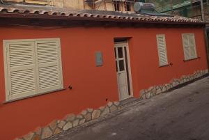 a red building with white windows and a street at Teo’s Holiday Home in Canino