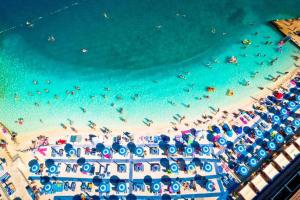 an overhead view of a beach with people and umbrellas at SEA HOUSE pool & jacuzzi - PRIVILEGE POINT camping & villas in Selce