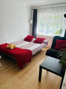 1 cama con almohadas rojas en una habitación con ventana en Fox hill view en Parkstone