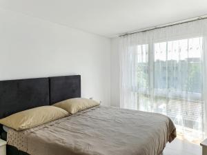 sypialnia z łóżkiem i dużym oknem w obiekcie Haus zur Lilie w mieście Hinwil