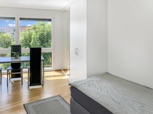 a bedroom with a bed and a desk and a window at Haus zur Lilie in Hinwil
