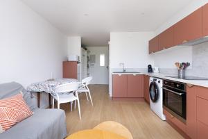 a kitchen with a couch and a table in a room at Le Balcon du Port - Joli studio à Capbreton in Capbreton