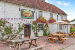 eine Gruppe Picknicktische vor einem Gebäude in der Unterkunft Tiger Inn - Elizabeth in Eastbourne