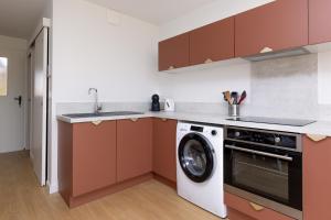 a kitchen with a washing machine and a sink at Le Balcon du Port - Joli studio à Capbreton in Capbreton +6 photos