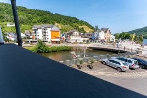 a group of cars parked in a parking lot next to a bridge at Moselresidenz Bellevue Alf Apartment Alfbach in Alf