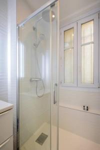 La salle de bains est pourvue d'une douche avec une porte en verre. dans l'établissement Goujon - Cozy apartment in Nation-Picpus neighborhood, à Paris