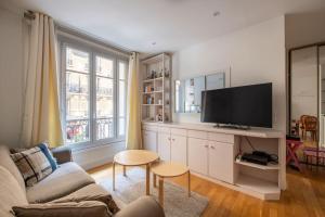 a living room with a couch and a flat screen tv at Goujon - Cozy apartment in Nation-Picpus neighborhood in Paris