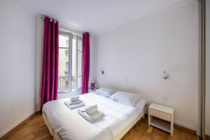 a bedroom with a white bed with red curtains and a window at Goujon - Cozy apartment in Nation-Picpus neighborhood in Paris