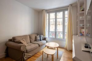 a living room with a couch and a table at Goujon - Cozy apartment in Nation-Picpus neighborhood in Paris