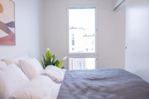 a white bedroom with a bed and a window at Snowflake Suites I in Rovaniemi