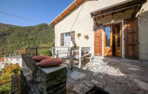 une maison avec une terrasse couverte et une porte en bois dans l'établissement Charming Le Pole in Vallico Sopra, à Bolognana