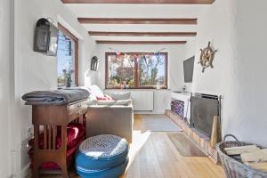 ein Wohnzimmer mit einem Tisch, einem Sofa und einem Fenster in der Unterkunft See-Chalet Riederau in Dießen am Ammersee
