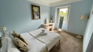 a blue bedroom with a bed and a window at North Middleton Apartment in North Middleton