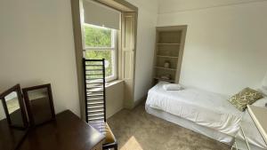 a small bedroom with a bed and a window at North Middleton Apartment in North Middleton