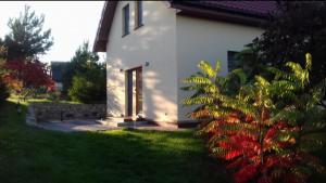 a white house with a plant in the yard at Rajski Azyl in Lidzbark