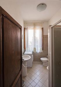 ein Bad mit einem Waschbecken, einem WC und einem Fenster in der Unterkunft Appartamenti immersi nelle colline Toscane in Molino Mazzetti